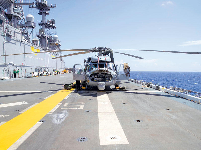 تجهيز مروحية هجومية على متن حاملة الطائرات «يو إس إس تريبولي» في المحيط الهادئ أمس (الأسطول السابع)
