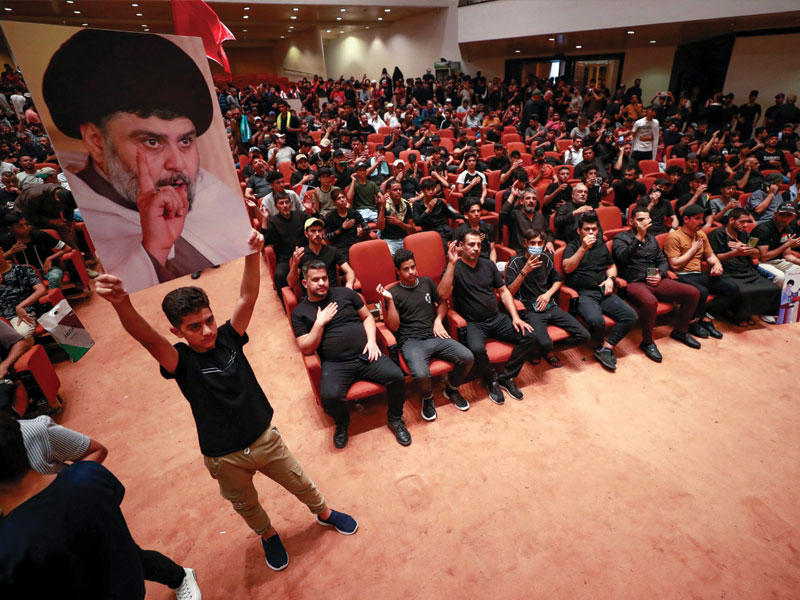 فتى يرفع صورة الصدر داخل إحدى قاعات البرلمان في خامس أيام اعتصام أنصاره بمقر المجلس (أ ف ب)