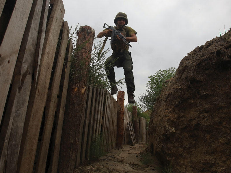 عنصر من الحرس الأوكراني يقفز داخل خندق على الجبهة في خاركيف (رويترز)