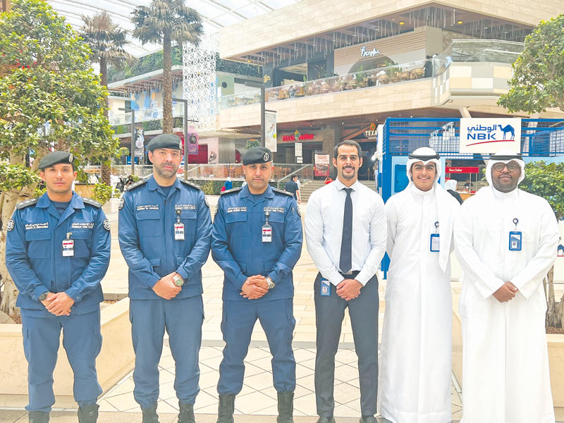 فريق عمل بنك الكويت الوطني مع مسؤولي «الإطفاء»
