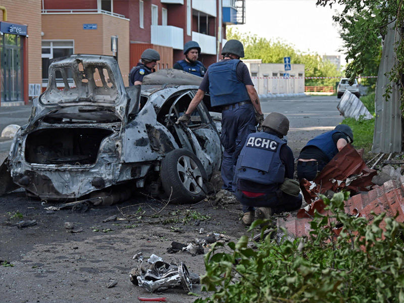 خبراء إزالة الألغام يفحصون موقع سقوط قذيفة عنقودية في شمال خاركيف (أ ف ب)