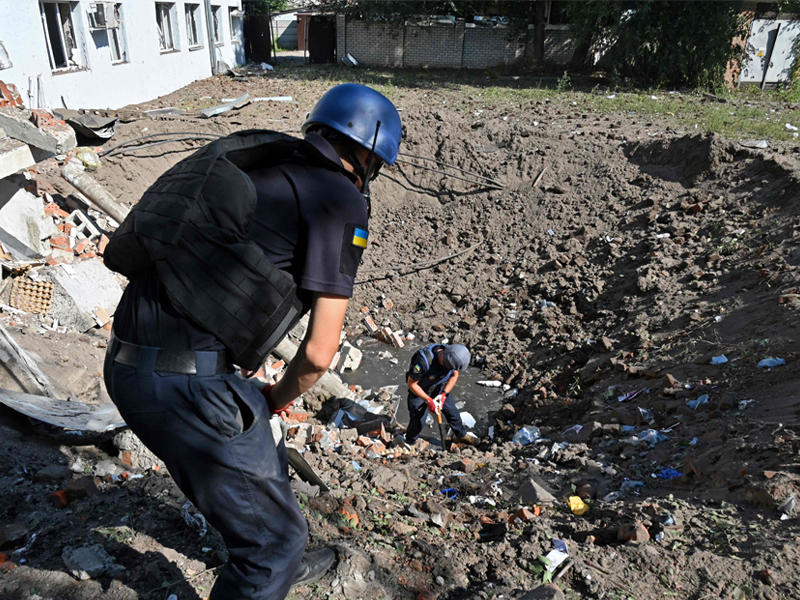 خبيرا ألغام بموقع مختبر طبي نسفه صاروخ روسي في خاركيف أمس  (أ ف ب)