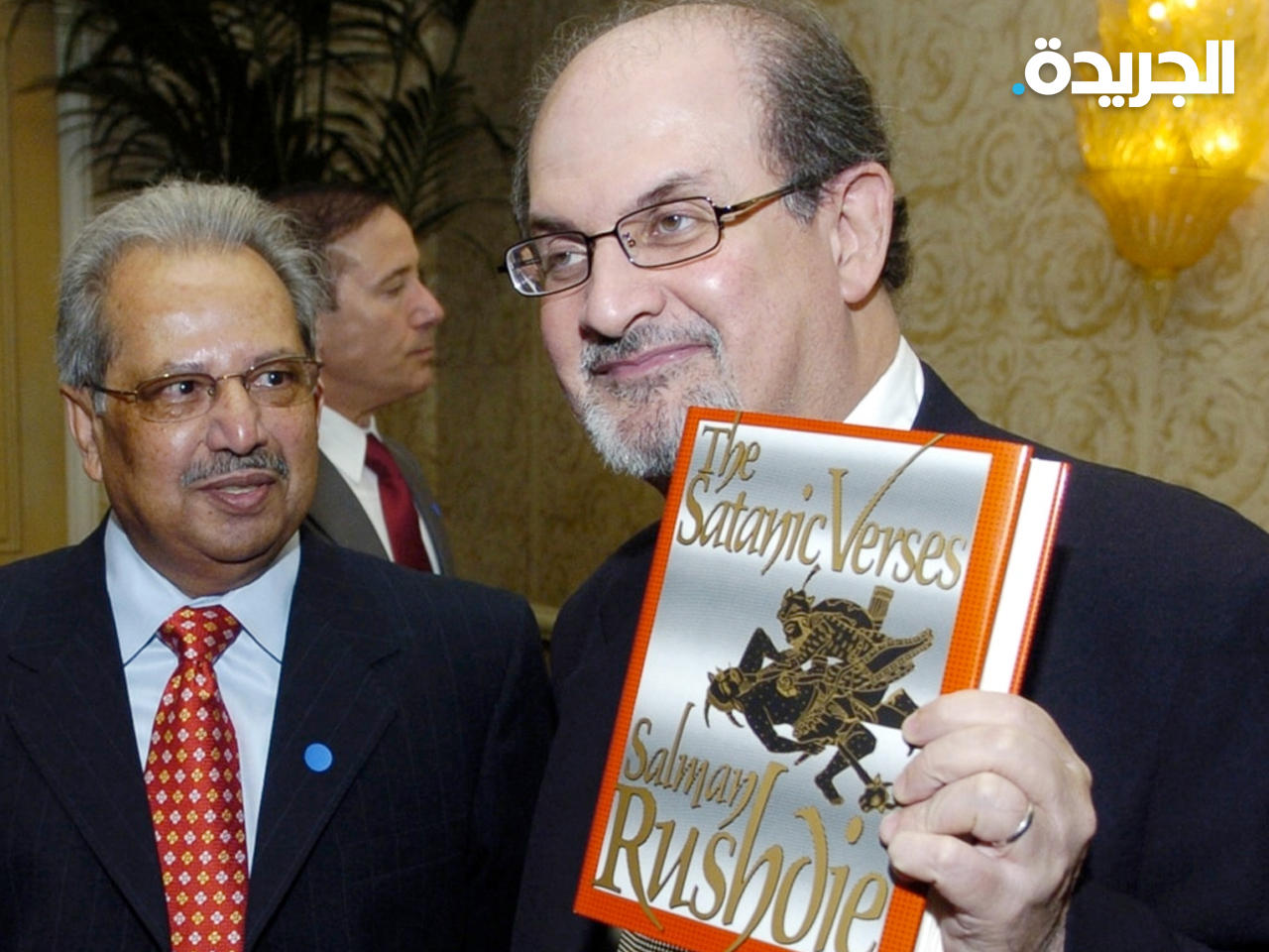 سلمان رشدي مع روايته «آيات شيطانية»