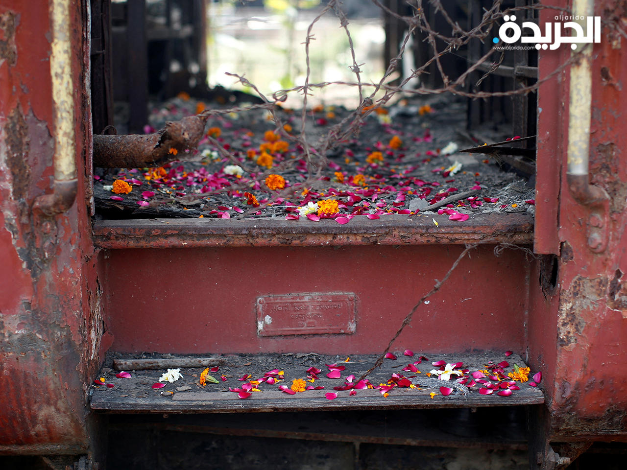 بتلات زهور متناثرة من قبل أقارب ضحايا أعمال الشغب في غوجارات تظهر على عتبات عربة قطار أضرمت فيها النيران
