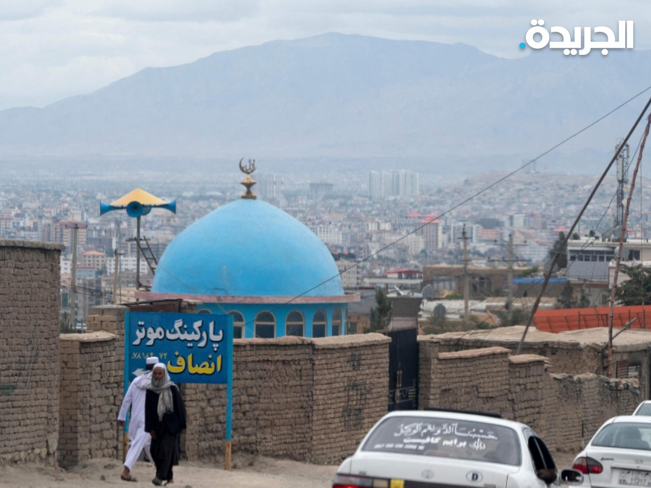 أفغان يمشون بالقرب من قبة مسجد زرقاء بعد يوم من الانفجار