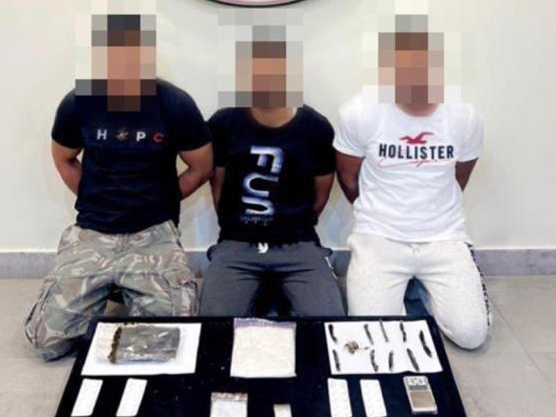 المتهمون وأمامهم المضبوطات