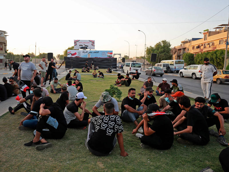 عراقيون بمحيط اعتصام أنصار «الإطار» قرب المنطقة الخضراء وسط بغداد أمس (أ ف ب)