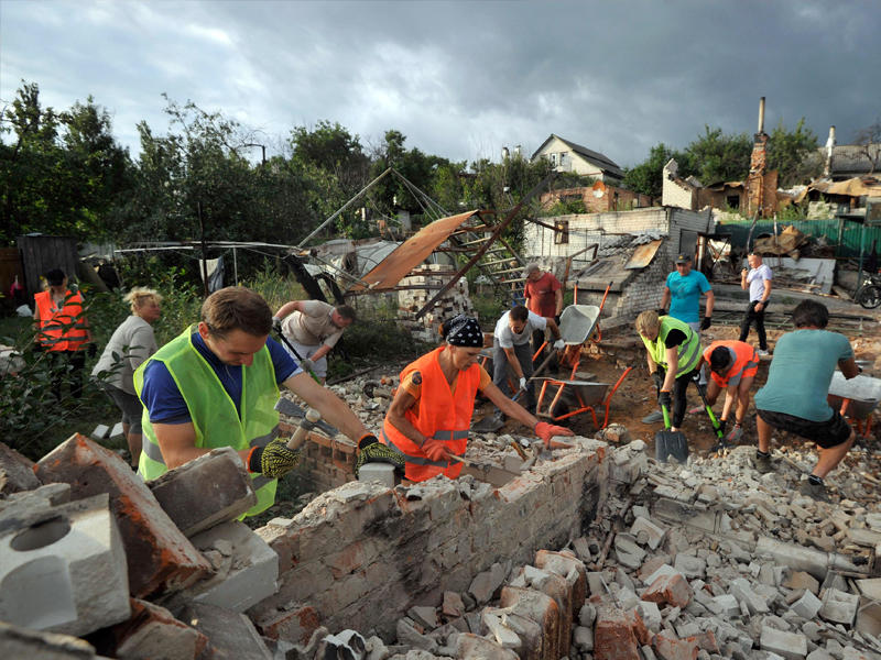 متطوعون يزيلون أنقاض منزل دمره القصف الروسي بمدينة تشيرنيهيف الأوكرانية (أ ف ب)