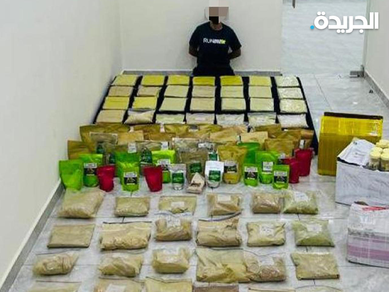 المتهم وأمامه المضبوطات