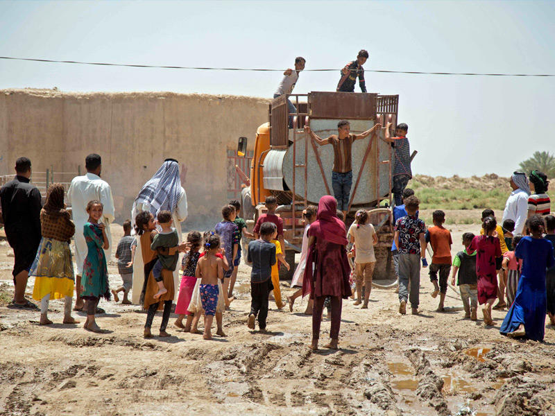 عراقيون يتزودون بالمياه في محافظة الديوانية وسط موجة جفاف تضرب عدة محافظات منتصف يوليو الماضي (أ ف ب)