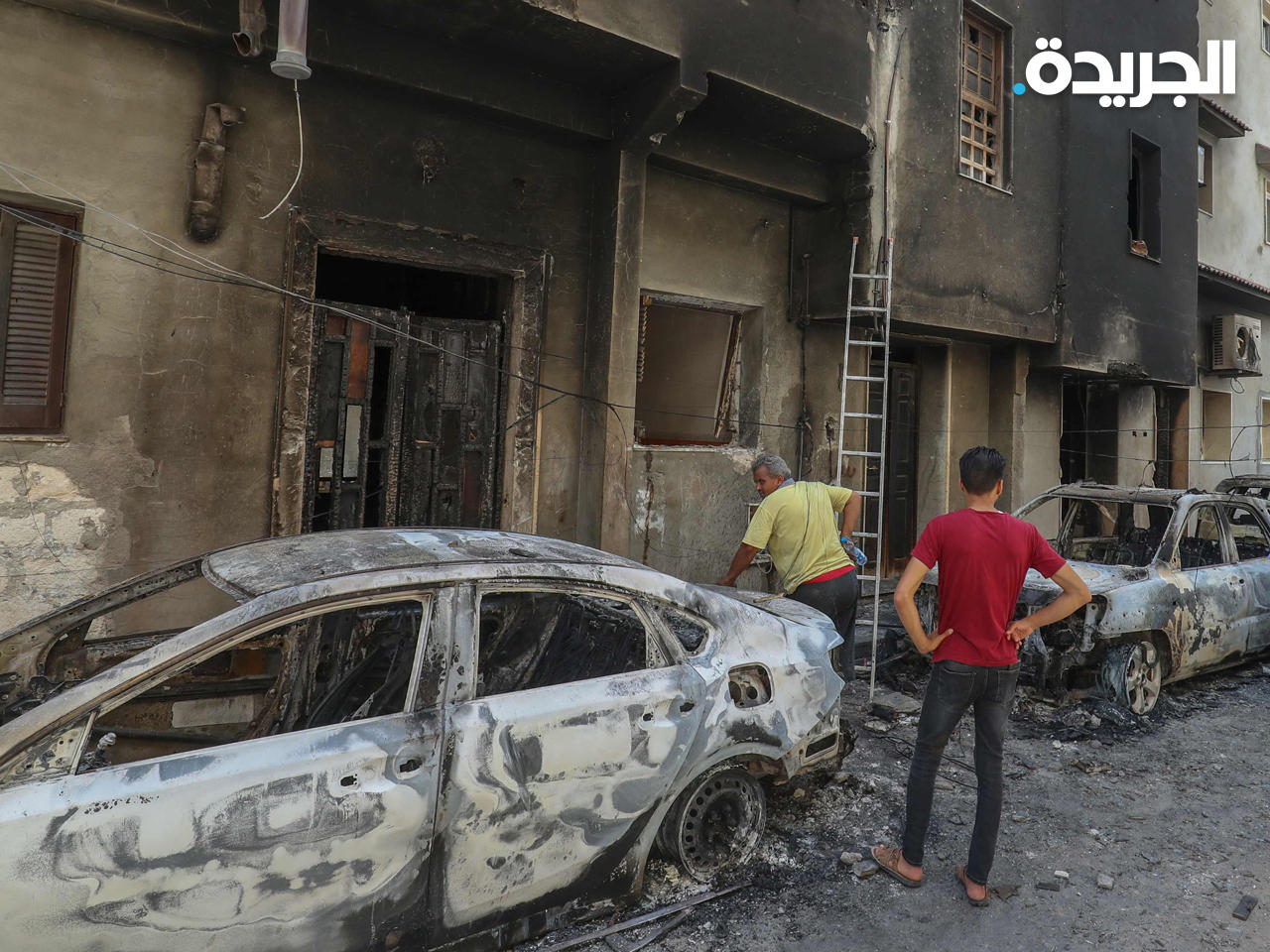 ليبيون يتفقدون الأضرار التي أعقبت الاشتباكات بين أنصار الحكومتين المتنافستين في العاصمة الليبية طرابلس