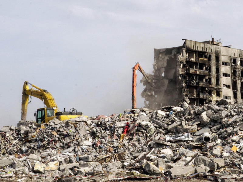 آليات تهدم عمارات متضررة بفعل الحرب في مدينة ماريوبول (أ ف ب)