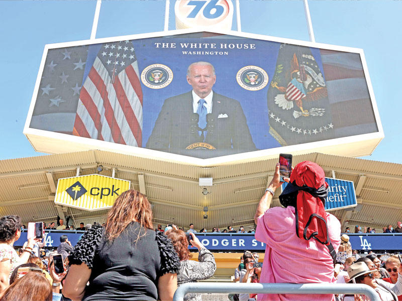 أفراد من المواطنين الجدد يستمعون إلى كلمة لبايدن في حفل التجنُّس بكاليفورنيا (أ ف ب)