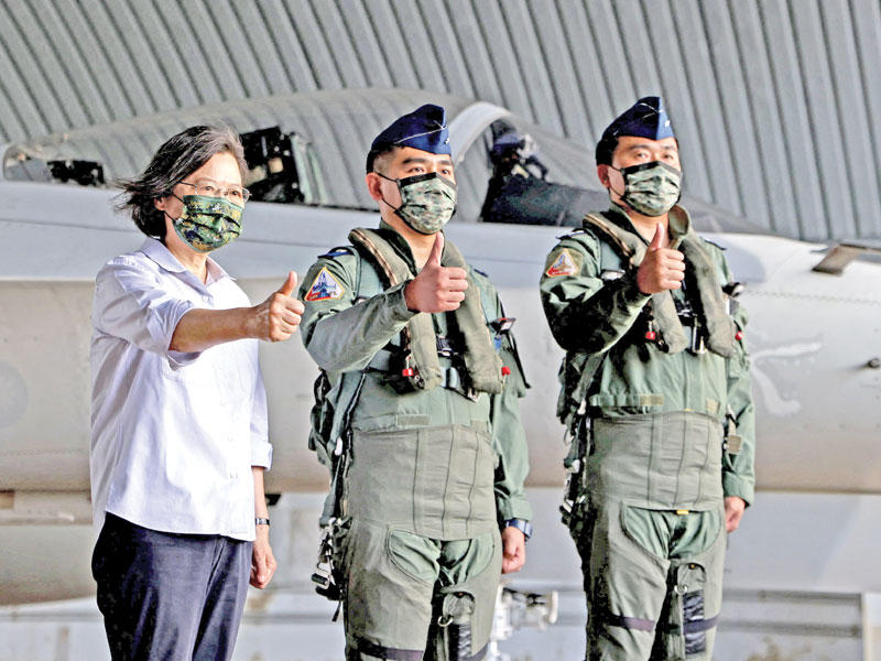 رئيسة تايوان مع طيارين في قاعدة بينغهو الجوية أمس (رويترز)