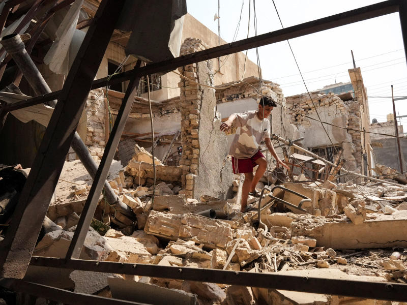 فتى وسط حطام مكتب للعصائب دمر خلال اشتباكات البصرة أمس (رويترز)