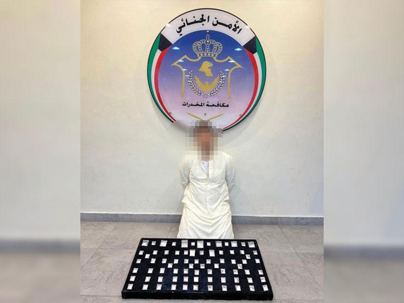 المتهم وأمامه المضبوطات