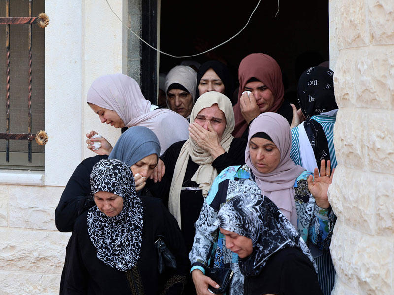 فلسطينيات في منزل الزقارنة بالقباطية أمس  (أ ف ب)