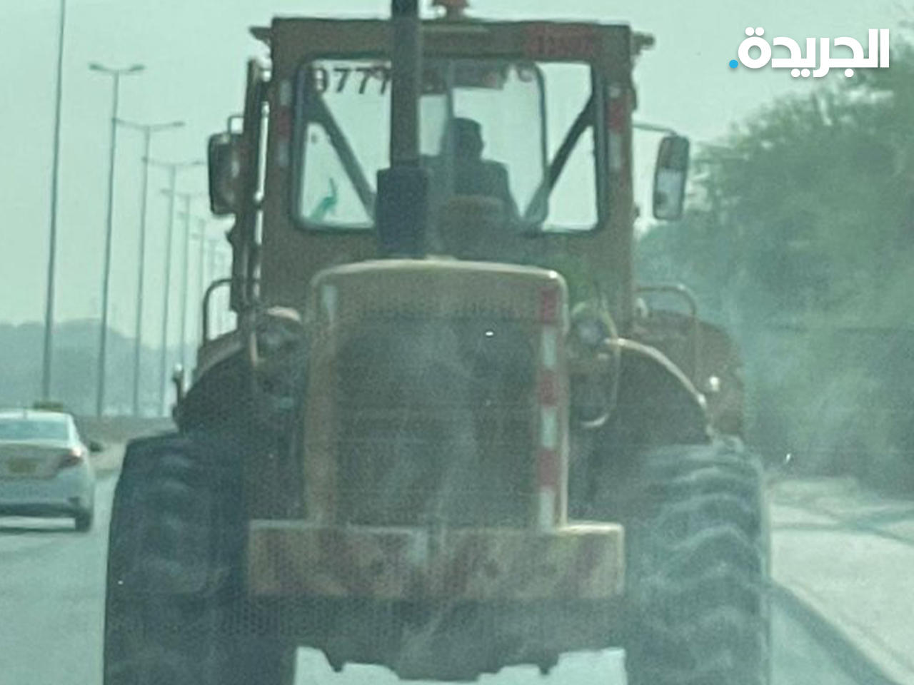 آلية إنشائية تسير على الطريق العام