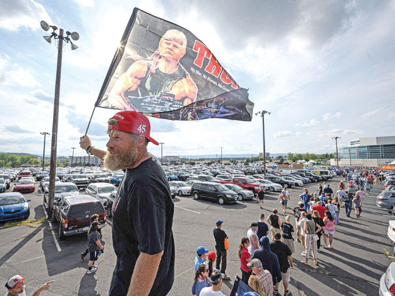 مناصر لترامب يحمل راية عليها صورة للرئيس السابق على شكل رامبو البطل الهوليوودي الشهير (أ ف ب)