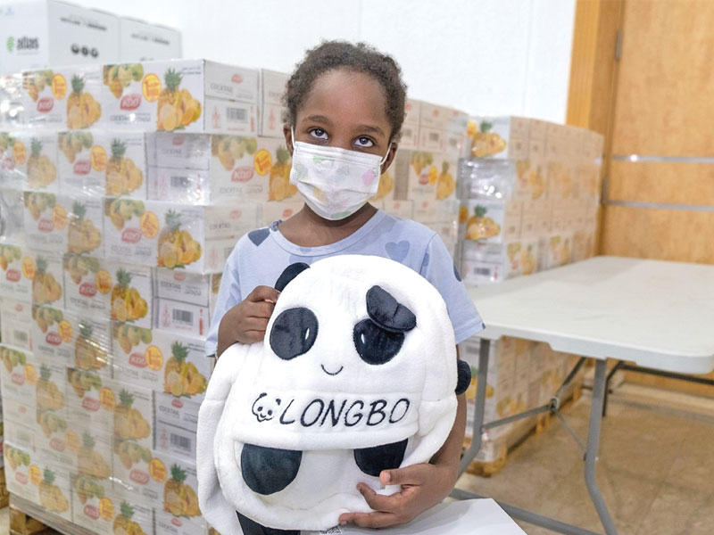 طفلة تتسلم حقيبتها المدرسية