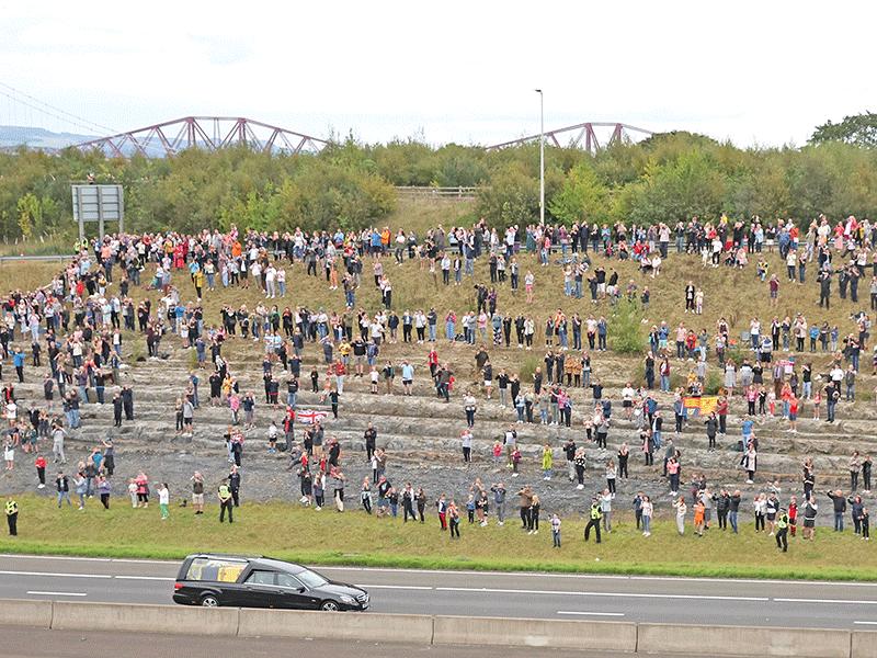 العشرات يواكبون مرور نعش الملكة في طريقه إلى إدنبره (رويترز)