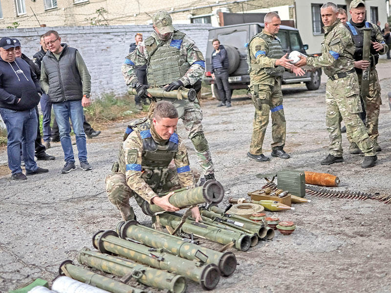 تجميع القذائف غير المنفجرة في بلدة زولوتشيف أمس الأول (رويترز)