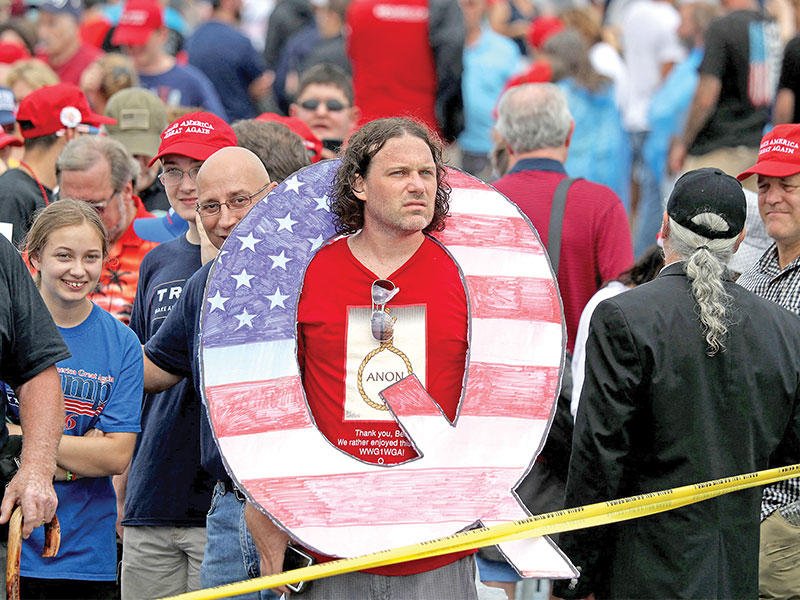 دايفيد راينرت يرتدي حرف (Q) خلال تجمع لترامب في 2018 (أ ف ب)