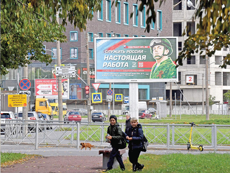 لوحة دعائية للخدمة العسكرية في سانت بطرسبرغ مكتوب عليها «خدمة روسيا وظيفة حقيقية» (أ ف ب)