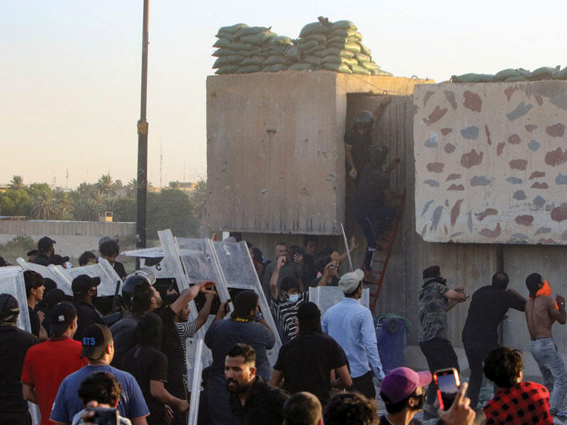 متظاهرون يحاولون اقتحام المنطقة الخضراء امس (رويترز)