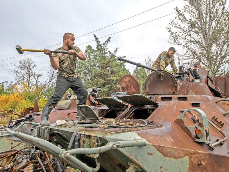 جندي أوكراني يفكك مدفعاً من حاملة جنود روسية قرب بلدة إيزيوم بمنطقة خاركيف (رويترز)