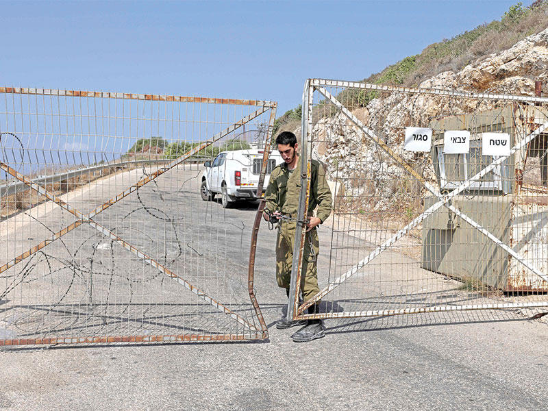 جندي إسرائيلي يغلق بوابة على حدود لبنان (أ ف ب)