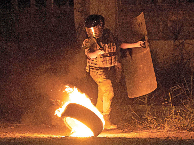 شرطي عراقي خلال تظاهرات في البصرة قبل أيام (أ ف ب)