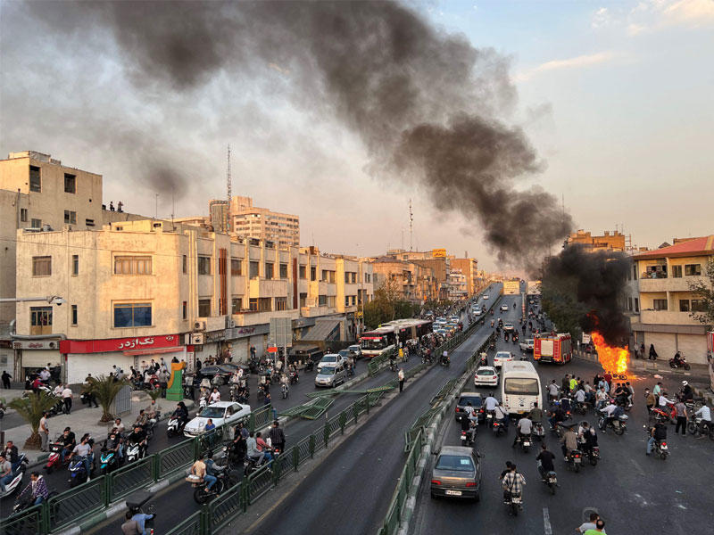 محتجون يضرمون النار في دراجة نارية وسط طهران أمس الأول (أ ف ب)