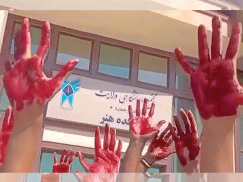 طلاب يرفعون أيديهم بلون الدم خلال احتجاجات في كلية الفنون بطهران أمس (أ ف ب)