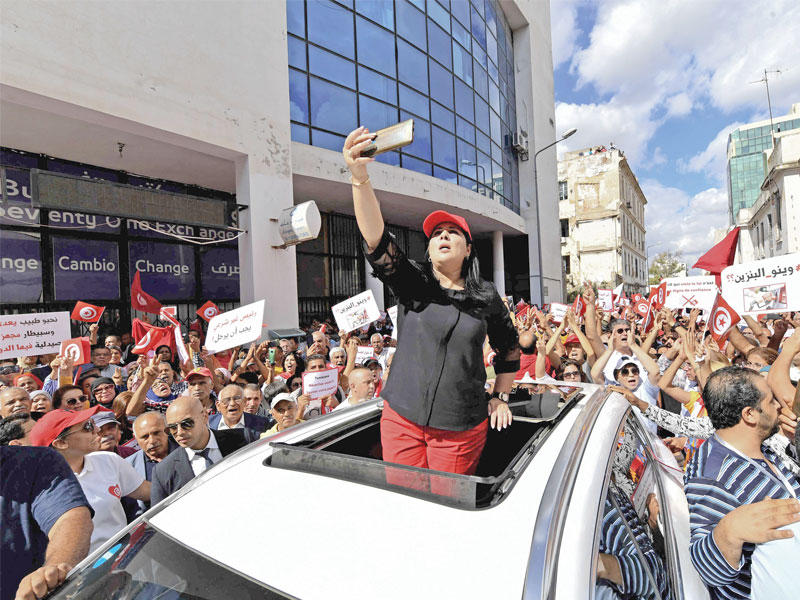تونسيون خلال تجمع احتجاجي في شارع أبورقيبة وسط العاصمة أمس (أ ف ب)