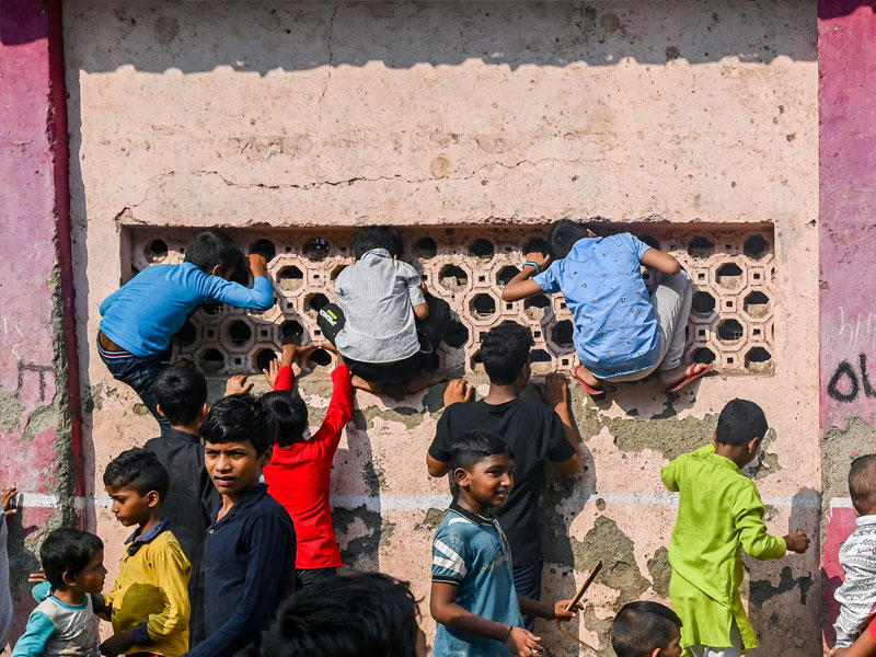 أطفال يتسلقون نوافذ مبنى مدرسة