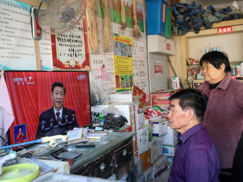 صينيان يتابعان خطاب شي من داخل متجرهما في مقاطعة انهوى الشرقية (ا ف ب)