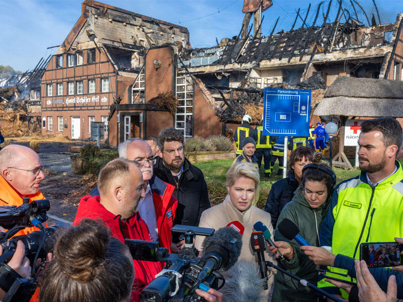 مسؤولون وصحافيون أمام مبنى للاجئين الأوكرانيين في ألمانيا أحرقه مجهولون (د ب أ)