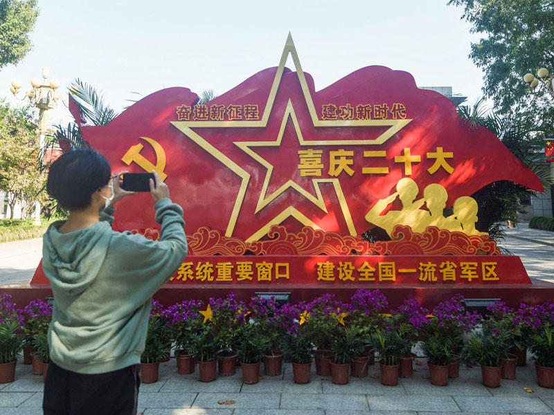 صيني يلتقط صوراً لمنشأة ترحب بالمؤتمر العشرين للحزب الشيوعي في هانغتشو بمقاطعة تشجيانغ (أ ف ب)